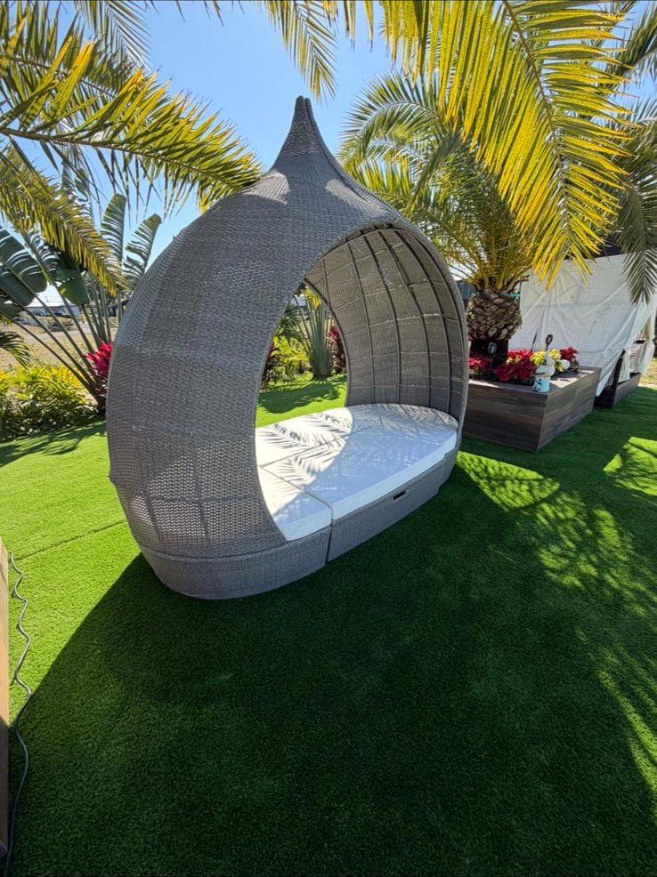 White mattress inside a wicker outdoor daybed