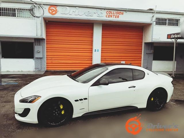 White Maserati GranTurismo in front of the Driver's Collision Center bays