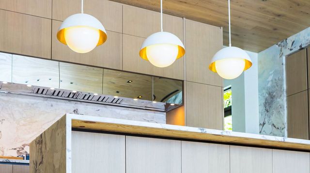 Kitchen with gold pendant lights and marble