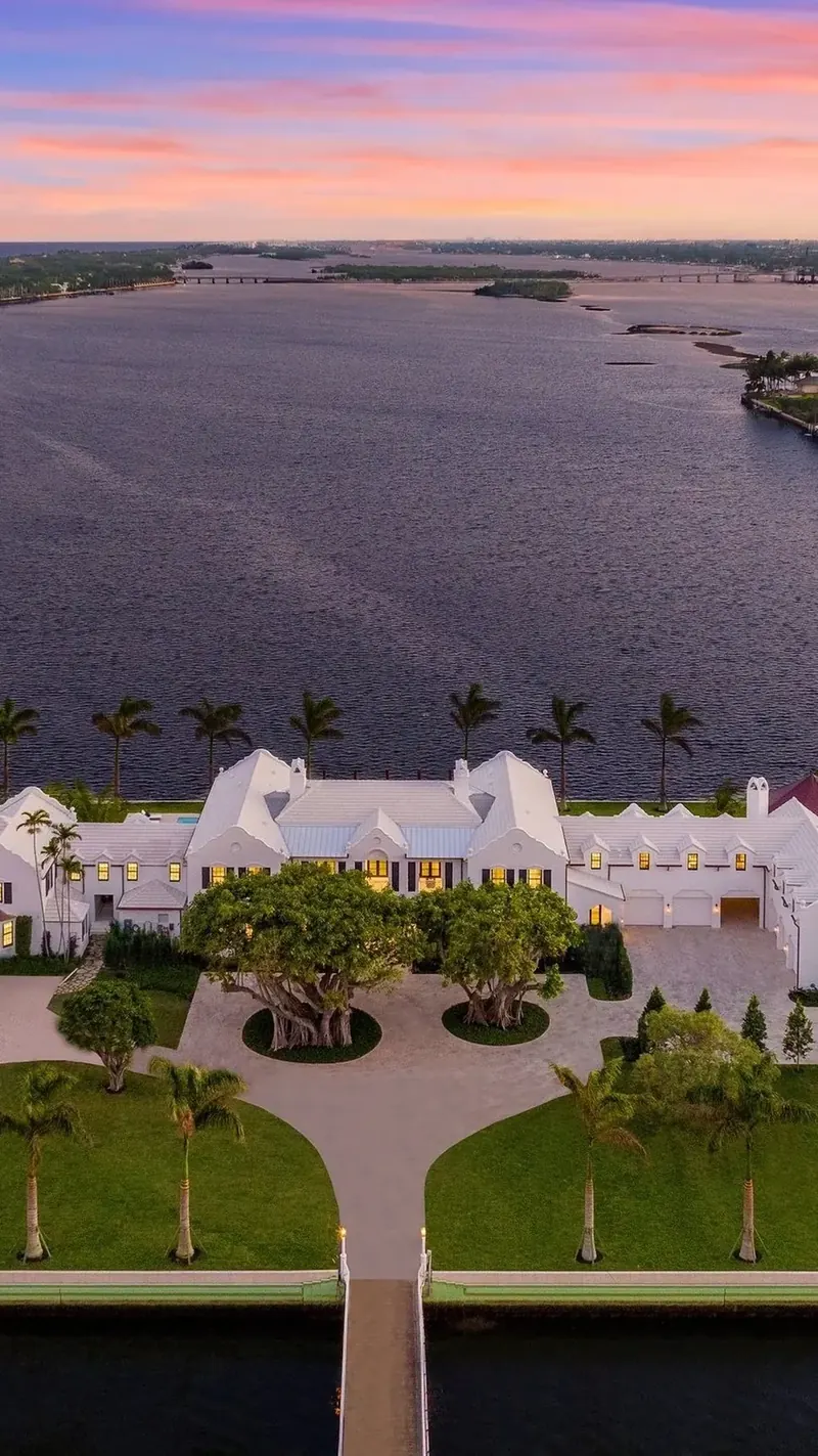 A private Palm Beach residence framed by expansive architectural glazing at dusk