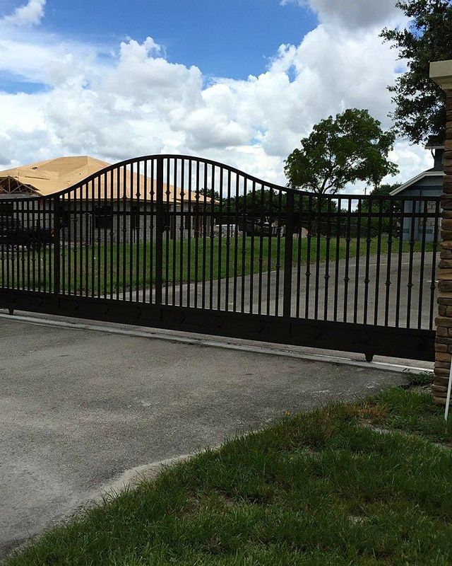 Driveway gate between stone pillars